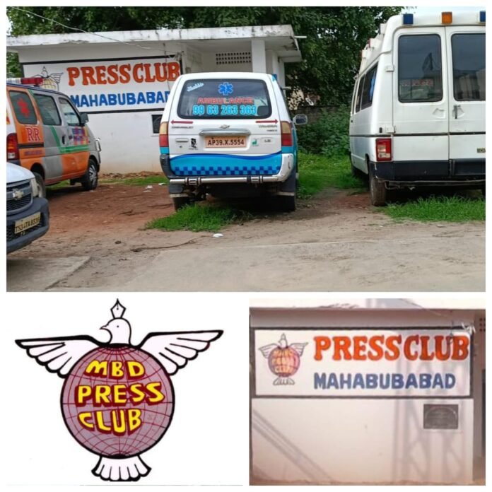 Manukota Press Club stands in front of the mortuary vehicles